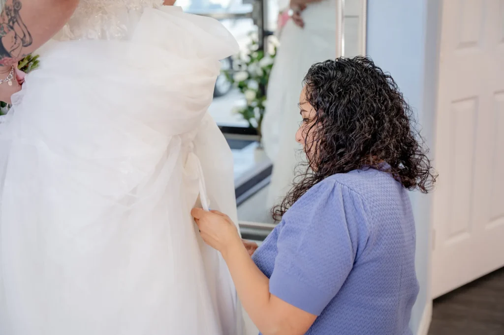 Professional seamstress adjusting wedding dress lining