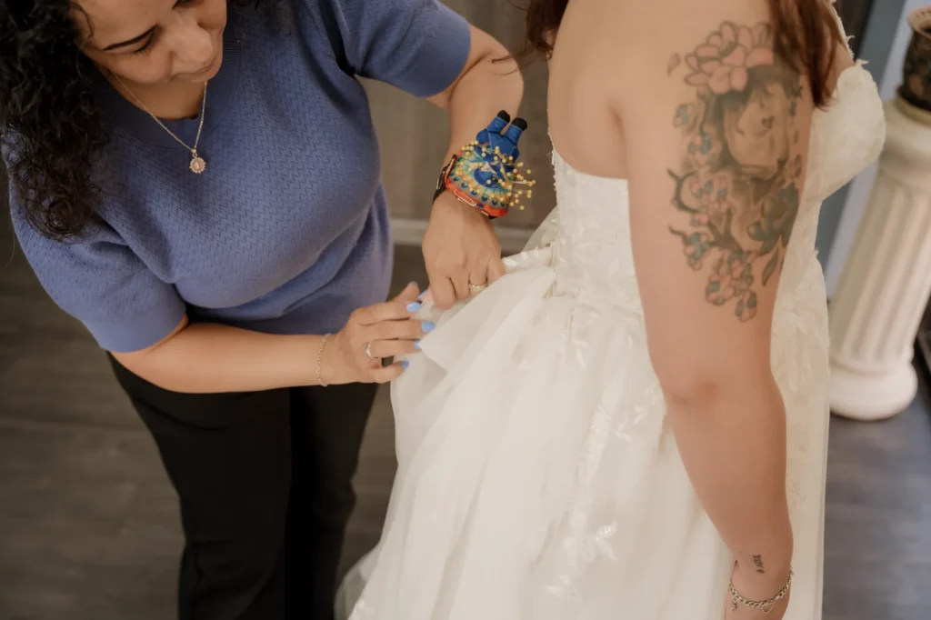 Professional seamstress adjusting bustle of wedding dress