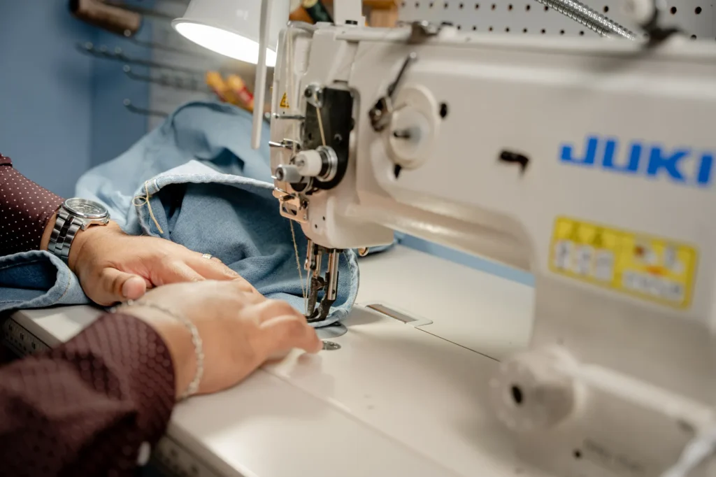 Expert tailor altering denim on a sewing machine